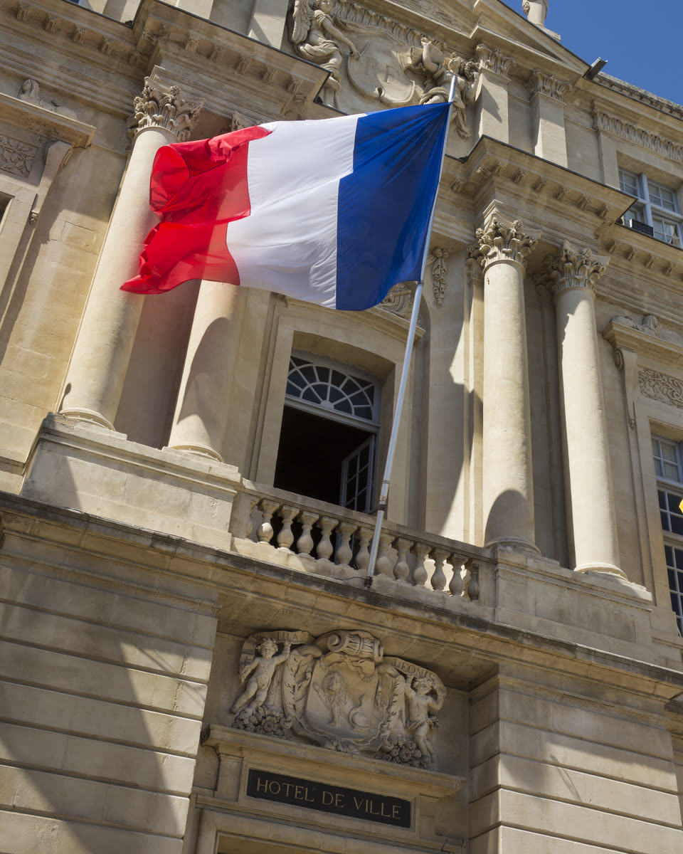 Le drapeau français sur la façade de l'hôtel de ville d'Arles